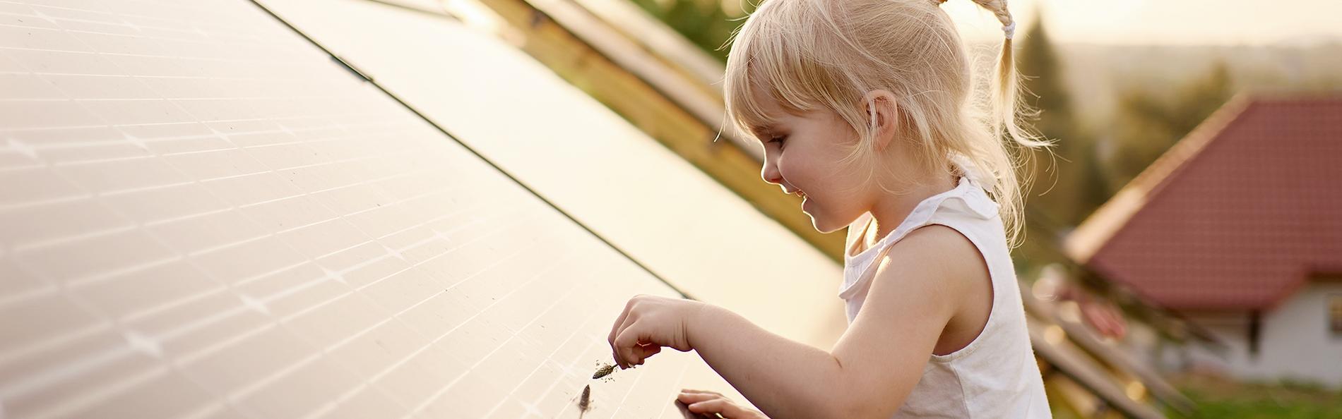 Kleines Mädchen spielt an Photovoltaikanlage