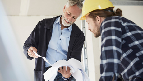 Architekt bespricht Plan mit Handwerker