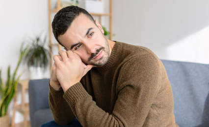 Junger Mann sitzt auf dem Sofa