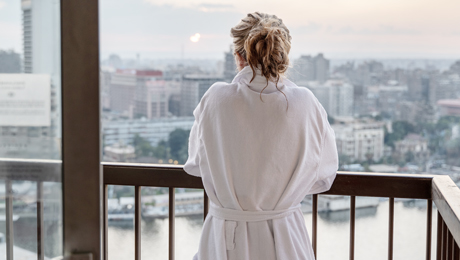 Frau im Bademantel auf dem Balkon